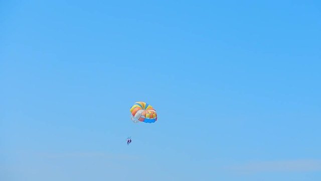 People go down on a parachute over the sea