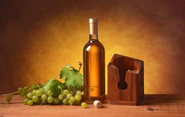 vino bianco con portabottiglie e grappolo di uva