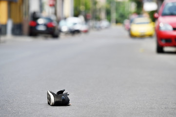 Fototapeta premium Shoe on the street with cars in background after accident