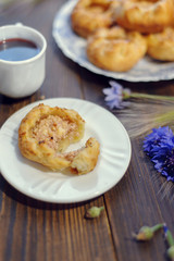 Baked open buns and a cup of tea on dark rustic wooden table. Selective focus. Blurred background
