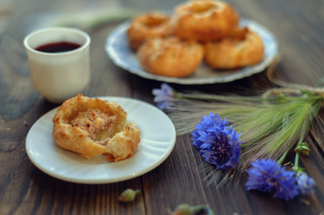 Baked open buns and a cup of tea on dark rustic wooden table. Selective focus. Blurred background
