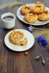 Baked open buns and a cup of tea on dark rustic wooden table. Selective focus. Blurred background