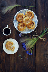 Baked open buns and a cup of tea on dark rustic wooden table. View from above