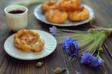 Baked open buns and a cup of tea on dark rustic wooden table. Selective focus. Blurred background