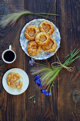 Baked open buns and a cup of tea on dark rustic wooden table. View from above