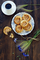 Baked open buns and a cup of tea on dark rustic wooden table. View from above