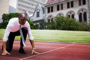 Fototapeta premium Composite image of close up of businessman in starting blocks