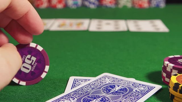 POKER: Player twirls a chip in the hand and thinks