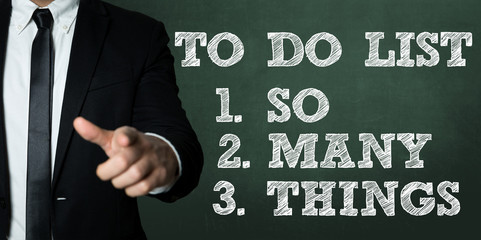 Business man pointing with the text: To Do List - So Many Things