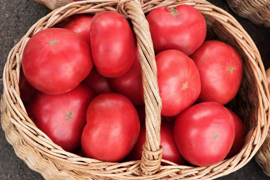 Big tomatoes in wooden basket. Top view, High resolution product.