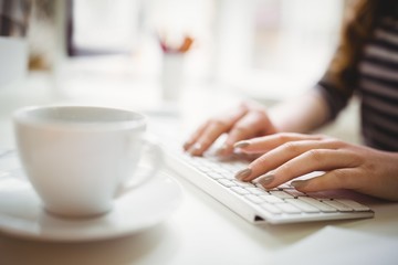 Businesswoman typing on keyboard in creative office