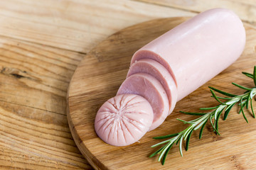 Sliced pork bologna salami with rosemary on the wooden board © zlajaphoto