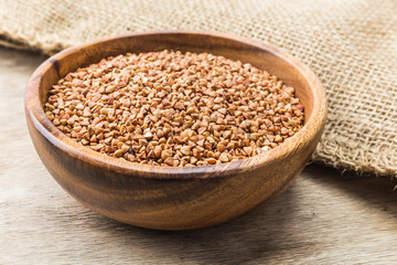 Bowl with Buckwheat on a wooden background