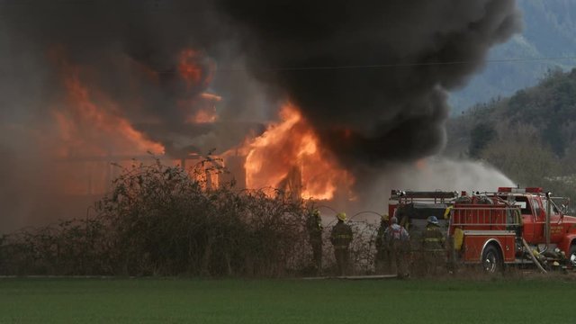 Firemen spraying water on a structure fire