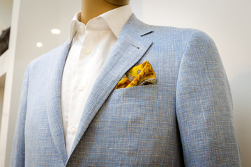 Blue business suit with a white shirt and with a yellow scarf in a pocket