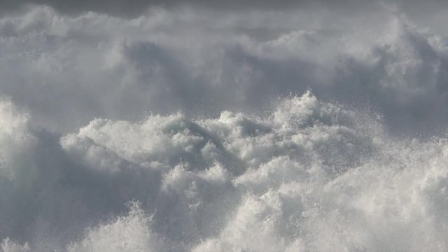 Churning foam from turbulent waves filling the frame and subsiding