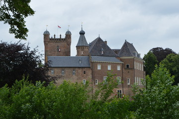 Fototapeta na wymiar Ommuurd middeleeuws kasteel met gracht in een Nederlands stadje 