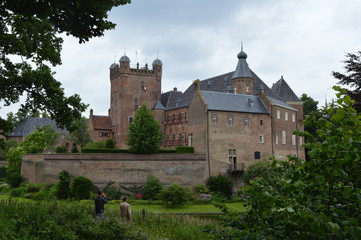 Fototapeta na wymiar Ommuurd middeleeuws kasteel met gracht in een Nederlands stadje 