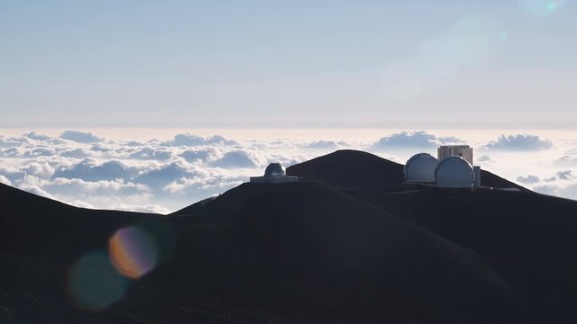 Past Mauna Loa Observatory with lens flares and a sea of clouds. Shot in 2010.
