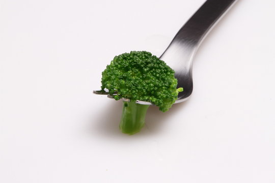 boild broccoli with salada fork on white background