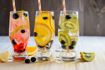 Variety of cold lemonade in a glass with fruit and berries