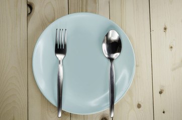 Plate and cutlery on wooden table