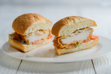 Fresh tasty chicken burger sectional view on wooden table