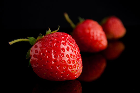 Juicy strawberries on a black background