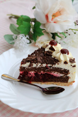A piece of Black Forest cake on the white plate with flowers
