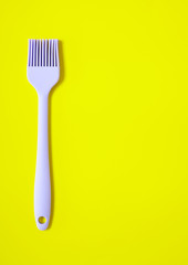 A pastry brush on a yellow background forming a baking themed a page border