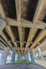 Freeway underpass with pillars and grass