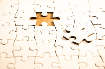 the hidden solution, white jigsaw/puzzle whit one gap, over  black wooden table background, symbol...