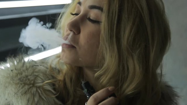 Attractive blonde woman dressed in fur jacket flirts