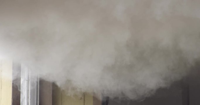Heavy gray smoke filling the upper portion of a room in a burning house
