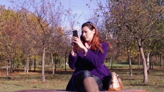 Woman Making Photo on Smartphone in Autumn Park