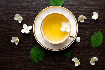 Jasmine tea in a porcelain Cup on a dark wood