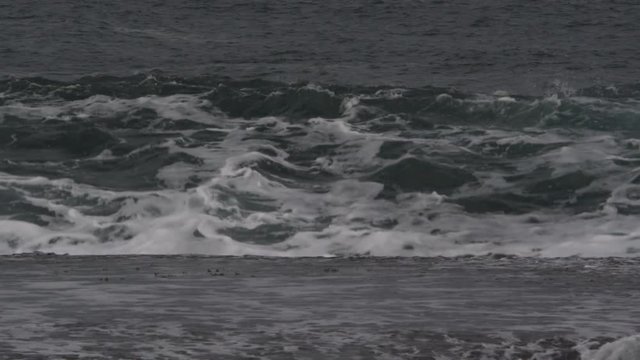 Close-up surging waves crashing onto a beach