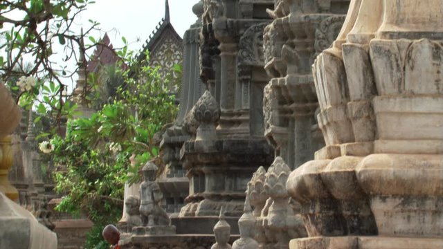 Cambodia: Tilt-down to Buddhist monk sweeping temple grounds
