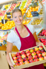 Woman holding a crate of fruit