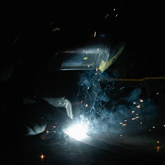 Fototapeta na wymiar Industrial Worker at the factory welding closeup