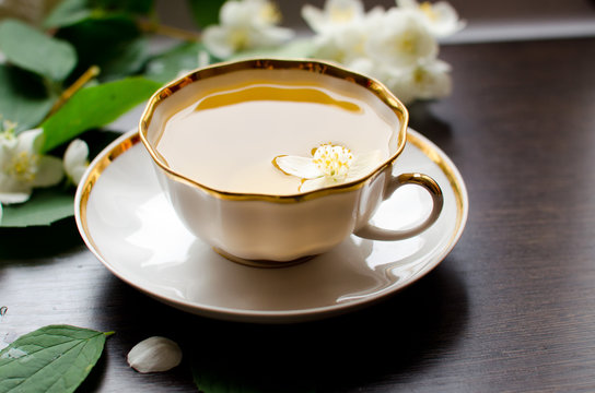 Jasmine tea in a porcelain Cup on a dark wood