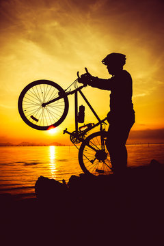 Silhouette of bicyclist enjoying the view at seaside. Outdoors.