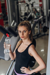 Beautiful blonde drinking water in the gym