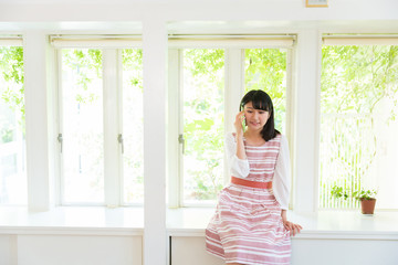 部屋で電話をする女性