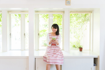 部屋でスマホを見る女性