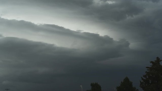 Layers of massed gray clouds blowing across the sky, time lapse