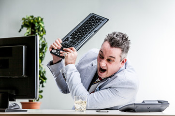 office worker destroying his computer