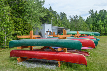 Group of canoes and kayaks on a green grass in park, Canada.