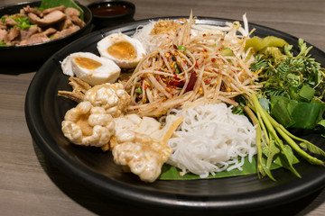 Som Tum or Thai style papaya salad in tray at restaurant