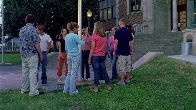 High school students gathered around a flag pole in an early morning prayer circle